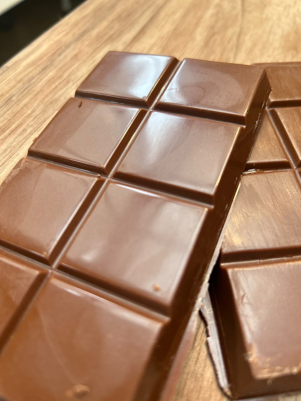 Detalhe de barras de chocolate Fertovane sobre uma mesa de madeira
